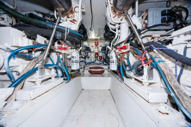 Loca Louise Yacht Photos Pics Engine room of a 2002 Hatteras 50 Convertible yacht, showcasing mechanical components and piping.