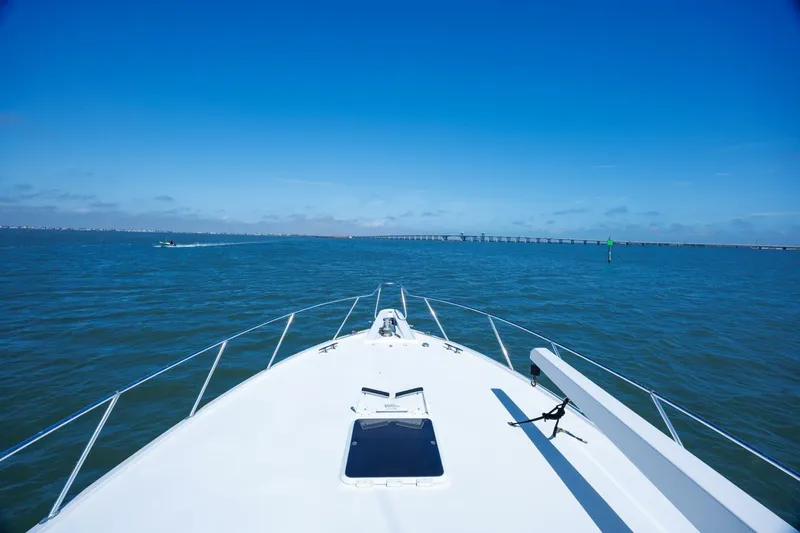 Loca Louise Yacht Photos Pics Bow view of 2002 Hatteras 50 Convertible yacht cruising on open water under clear blue sky.