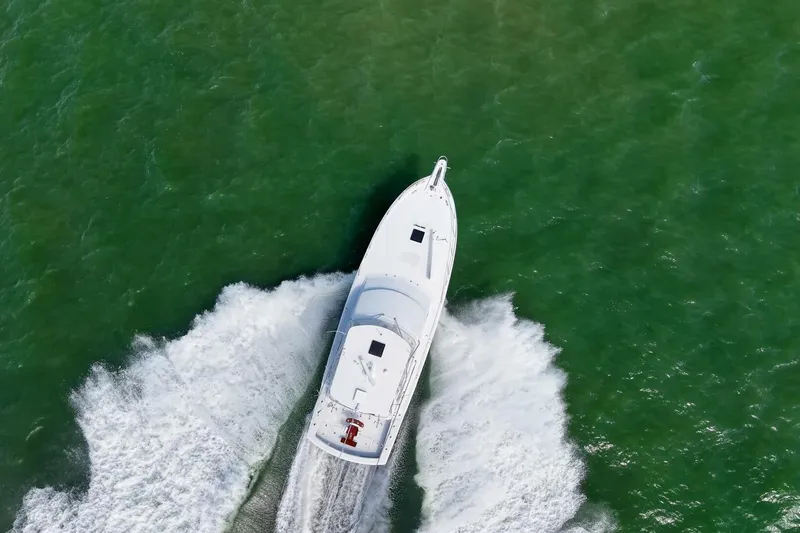 Loca Louise Yacht Photos Pics Aerial view of 2002 Hatteras 50 Convertible yacht cruising on green water.