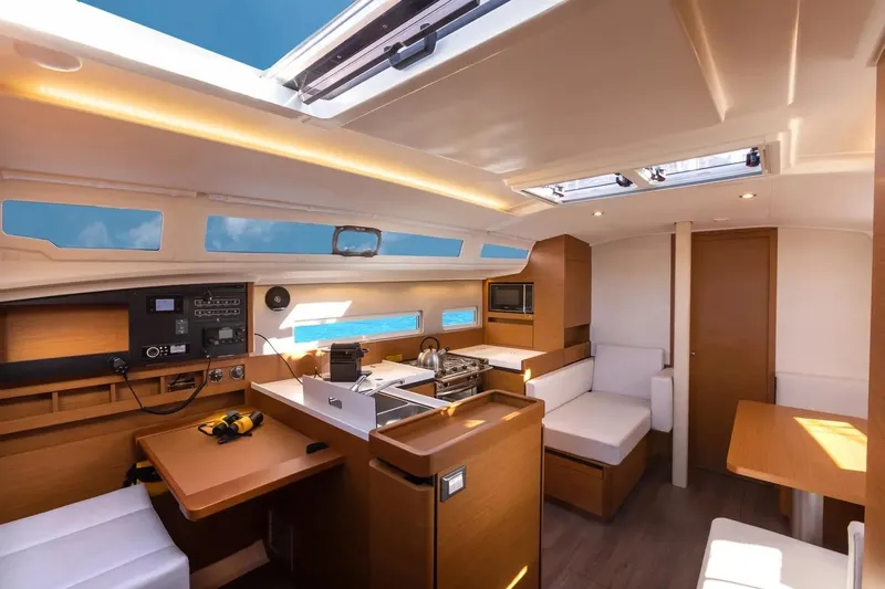  Yacht Photos Pics Interior of 2021 Jeanneau Sun Odyssey 410 yacht, featuring modern kitchen and seating area.