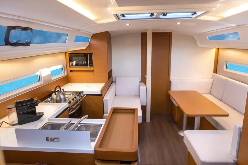  Yacht Photos Pics Interior of 2021 Jeanneau Sun Odyssey 410 yacht, featuring modern kitchen and seating area.