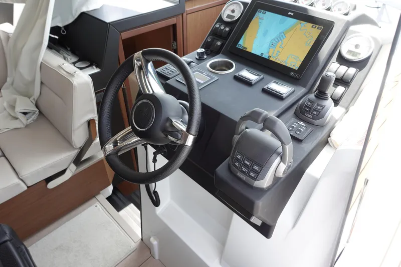 Somedays Here Yacht Photos Pics 2021 Jeanneau NC 37 helm with steering wheel, navigation display, and control panel.