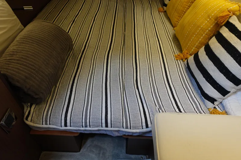 Somedays Here Yacht Photos Pics Cozy cabin bed with striped bedding and decorative pillows on Jeanneau NC 37, 2021 model.