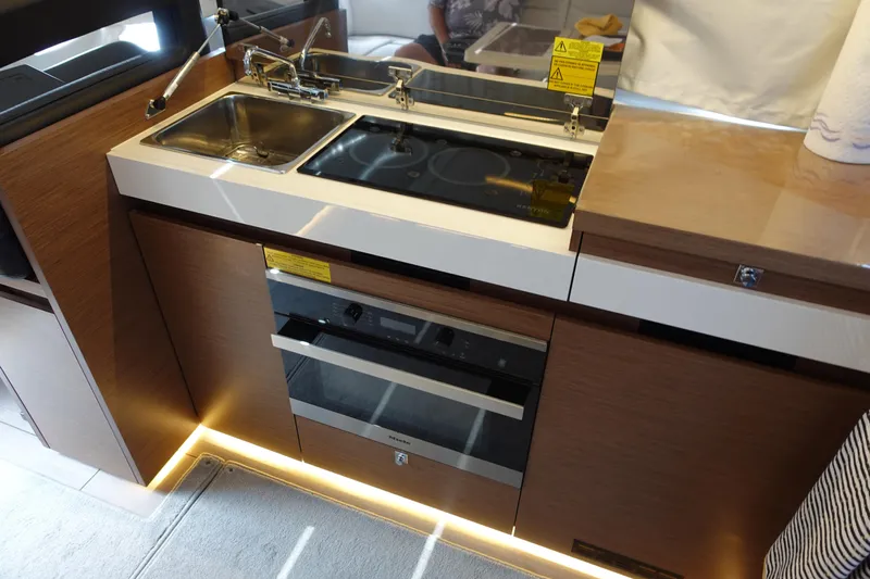 Somedays Here Yacht Photos Pics Modern kitchen area in a 2021 Jeanneau NC 37 boat, featuring a sink and stove.