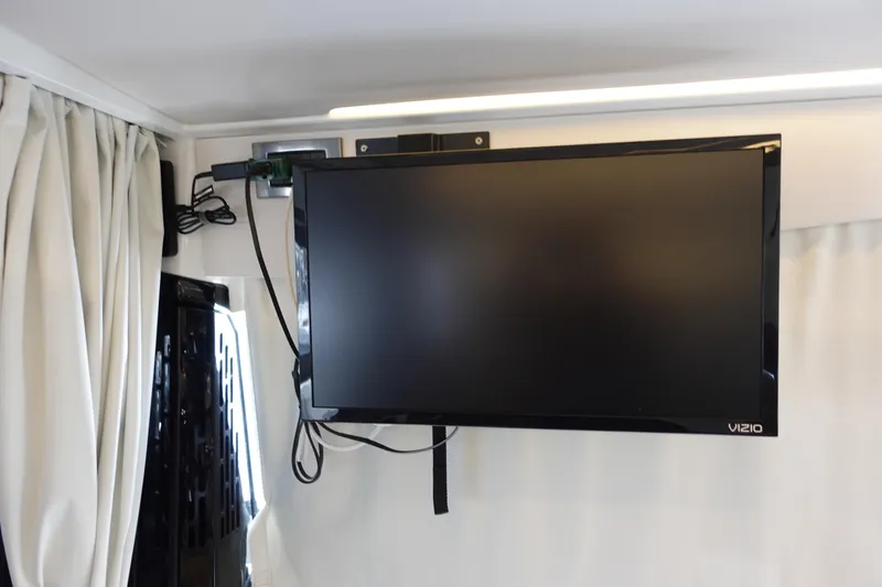 Somedays Here Yacht Photos Pics Vizio TV mounted inside 2021 Jeanneau NC 37 boat, with curtains and cables visible.