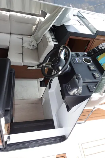 Somedays Here Yacht Photos Pics Interior view of 2021 Jeanneau NC 37 boat cockpit with steering wheel and seating area.