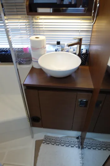 Somedays Here Yacht Photos Pics Modern bathroom interior of 2021 Jeanneau NC 37 yacht with sink and wooden cabinetry.