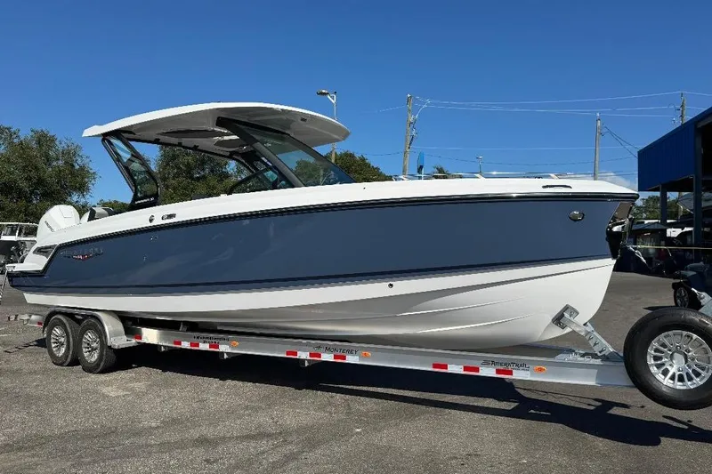  Yacht Photos Pics 2026 Monterey Elite 30 OB boat on trailer, sleek design, blue and white color scheme.