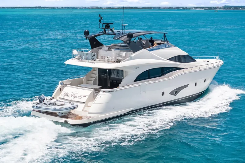  Yacht Photos Pics Luxurious 2016 Marquis 720 Fly Bridge yacht cruising on clear blue ocean waters.