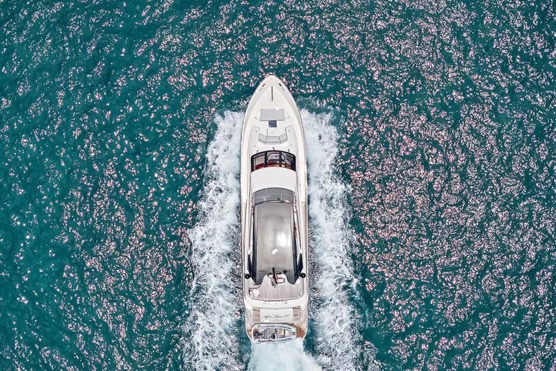  Yacht Photos Pics Aerial view of 2016 Marquis 720 Fly Bridge yacht cruising on sparkling blue water.