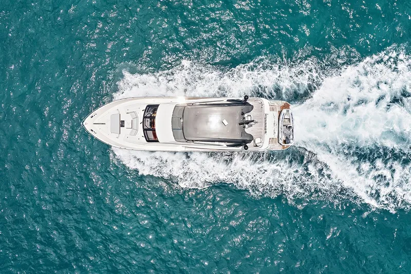  Yacht Photos Pics Aerial view of 2016 Marquis 720 Fly Bridge yacht cruising in blue ocean waters.
