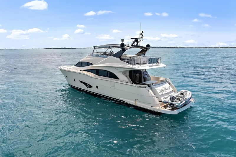  Yacht Photos Pics Luxurious 2016 Marquis 720 Fly Bridge yacht cruising on open water.