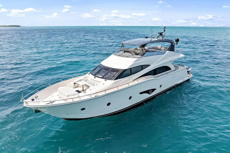  Yacht Photos Pics Luxurious 2016 Marquis 720 Fly Bridge yacht cruising on clear blue ocean waters.