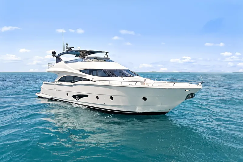  Yacht Photos Pics 2016 Marquis 720 Fly Bridge yacht cruising on open sea under clear blue sky.