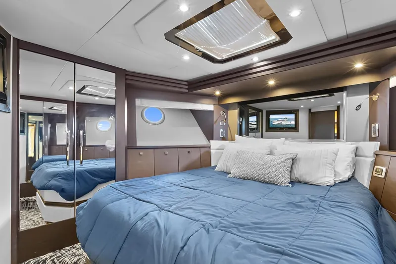  Yacht Photos Pics Luxurious 2016 Marquis 720 Fly Bridge yacht bedroom with blue bedding and modern decor.