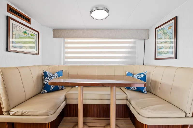  Yacht Photos Pics 1989 Hatteras 70 Motor Yacht interior dining area with beige seating and wooden table.