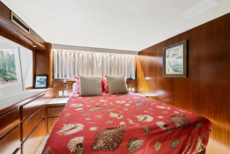  Yacht Photos Pics Cozy bedroom in 1989 Hatteras 70 Motor Yacht with red seashell-themed bedding.