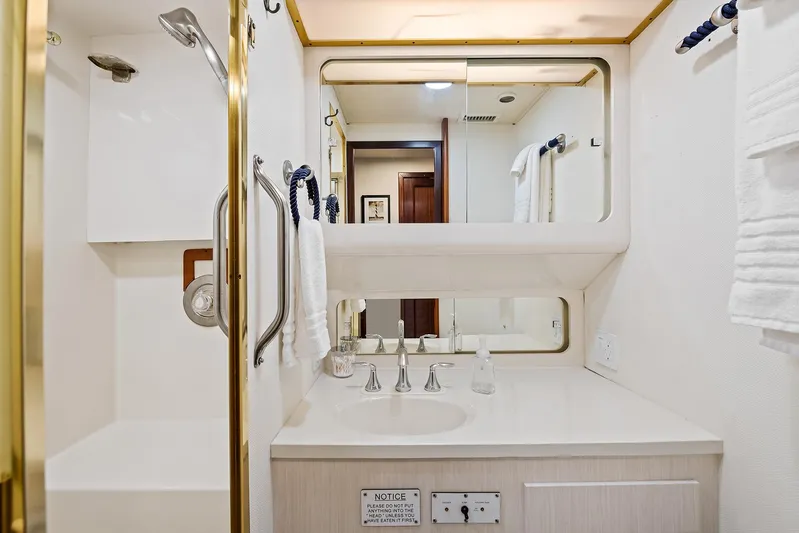  Yacht Photos Pics 1989 Hatteras 70 Motor Yacht bathroom with sink, mirror, and shower.