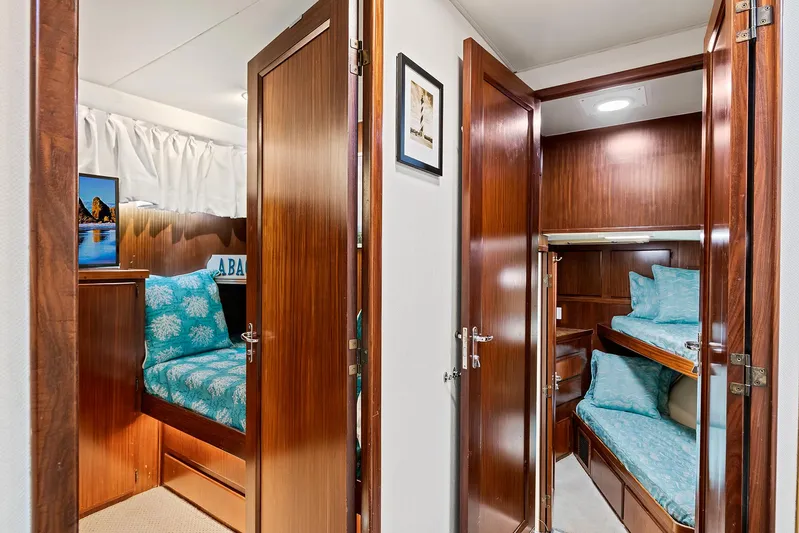  Yacht Photos Pics Interior cabin of 1989 Hatteras 70 Motor Yacht with wooden doors and blue bedding.