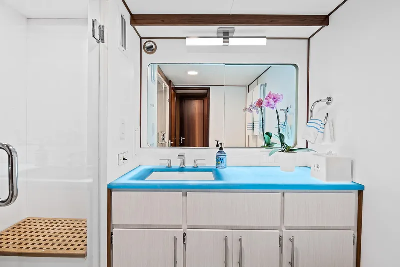  Yacht Photos Pics Modern bathroom on 1989 Hatteras 70 Motor Yacht with blue countertop and large mirror.