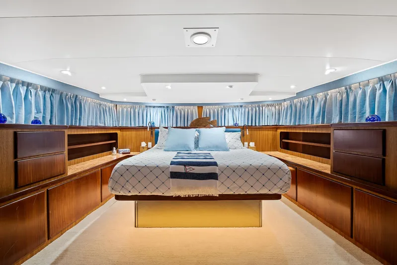  Yacht Photos Pics Luxurious master bedroom on a 1989 Hatteras 70 Motor Yacht with elegant wood cabinetry.