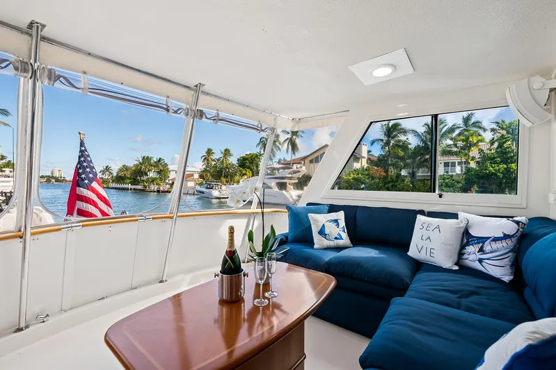  Yacht Photos Pics Interior of 1989 Hatteras 70 Motor Yacht with blue sofa, table, and waterfront view.