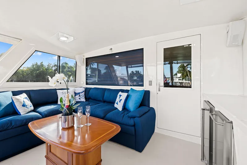  Yacht Photos Pics Interior of 1989 Hatteras 70 Motor Yacht with blue seating and wooden table.