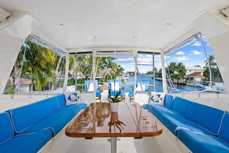  Yacht Photos Pics Interior of 1989 Hatteras 70 Motor Yacht with blue seating and wooden table.