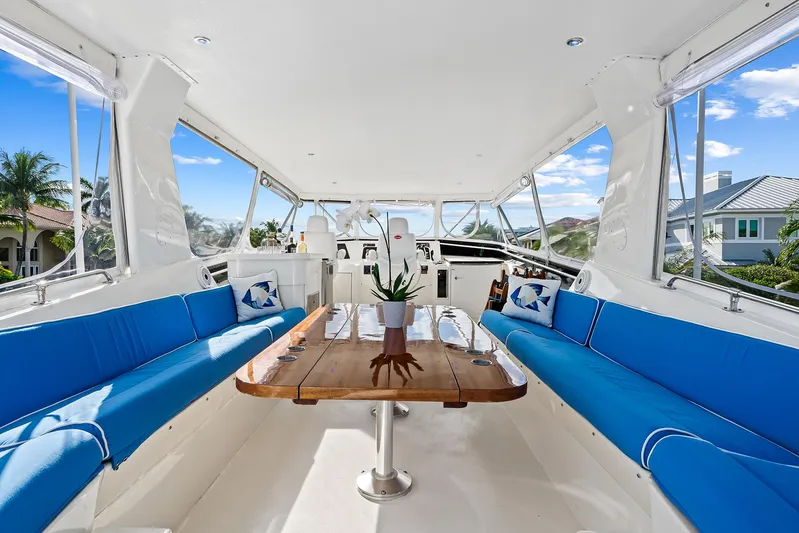  Yacht Photos Pics Interior of 1989 Hatteras 70 Motor Yacht with blue seating and wooden table.