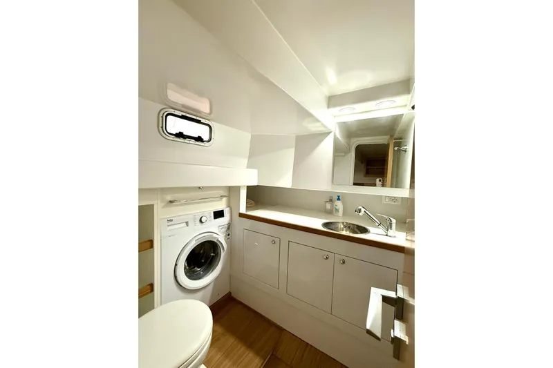  Yacht Photos Pics Modern bathroom with washer, sink, and mirror in 2023 Zeta Elle 20 model.