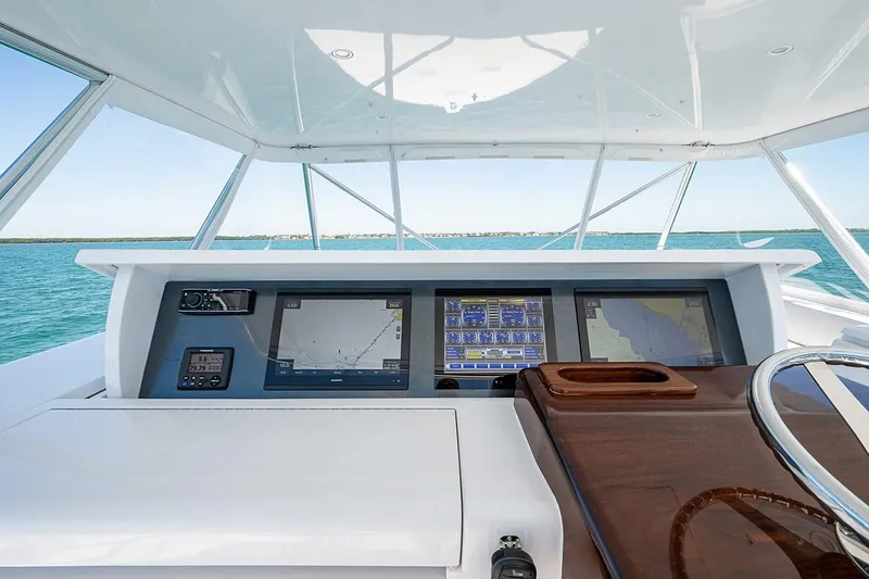 Cast Away Yacht Photos Pics Helm of 2008 Hatteras 68 Convertible yacht with navigation screens and steering wheel.
