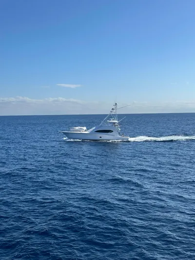 Cast Away Yacht Photos Pics 2008 Hatteras 68 Convertible yacht cruising on open sea under clear blue sky.