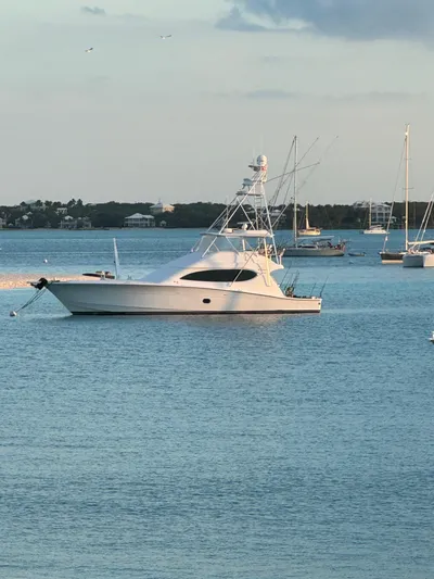 Cast Away Yacht Photos Pics 2008 Hatteras 68 Convertible yacht anchored in calm waters.