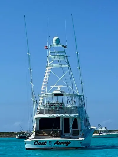 Cast Away Yacht Photos Pics 2008 Hatteras 68 Convertible yacht on clear blue water, rear view.