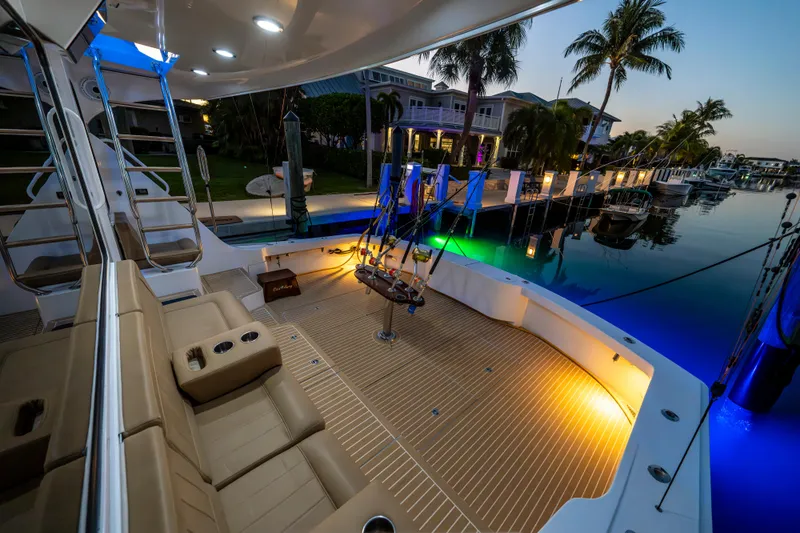 Cast Away Yacht Photos Pics Luxurious 2008 Hatteras 68 Convertible yacht docked at sunset, featuring elegant seating and ambient lighting.