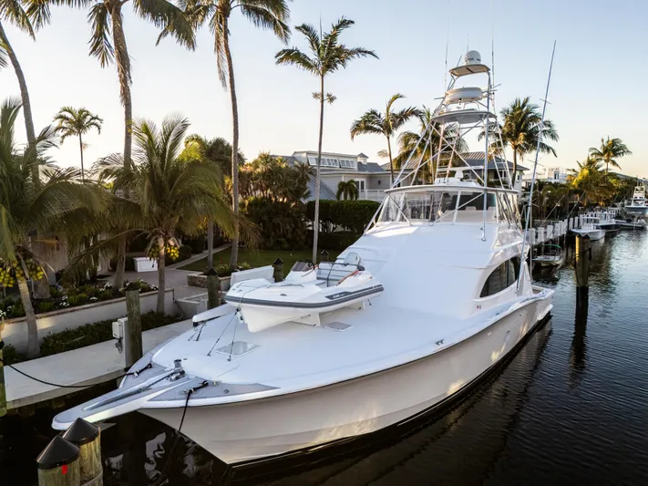 Cast Away Yacht Photos Pics 2008 Hatteras 68 Convertible yacht docked by palm trees in a serene marina.
