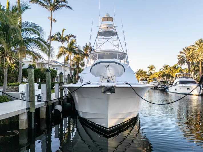Cast Away Yacht Photos Pics 2008 Hatteras 68 Convertible yacht docked in a tropical marina with palm trees.