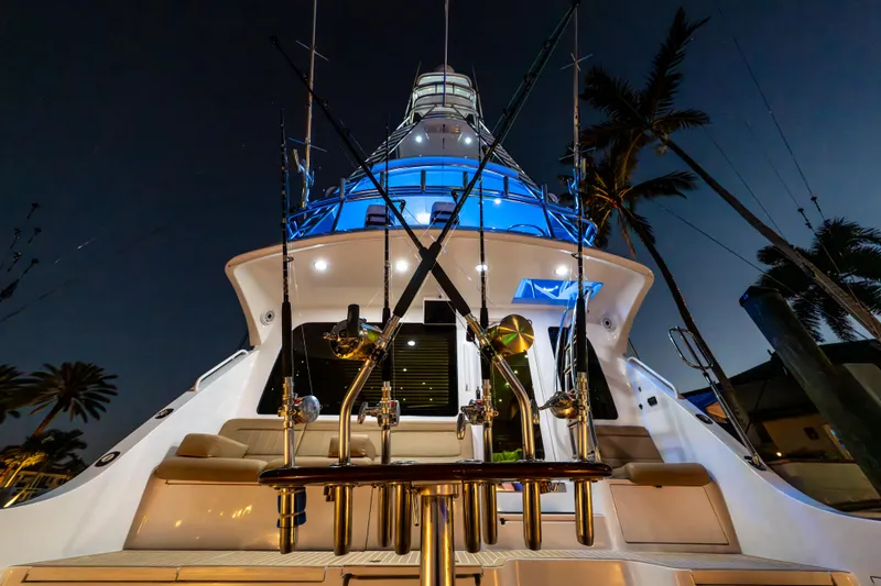 Cast Away Yacht Photos Pics 2008 Hatteras 68 Convertible yacht illuminated at night, showcasing fishing rods and sleek design.
