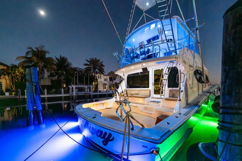 Cast Away Yacht Photos Pics 2008 Hatteras 68 Convertible yacht with vibrant underwater lights at night.