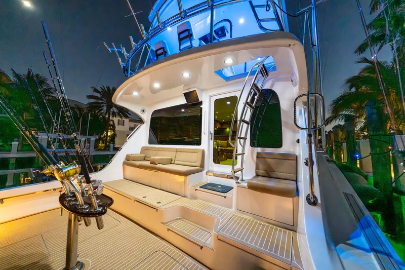 Cast Away Yacht Photos Pics 2008 Hatteras 68 Convertible yacht deck with seating and fishing rods at night.