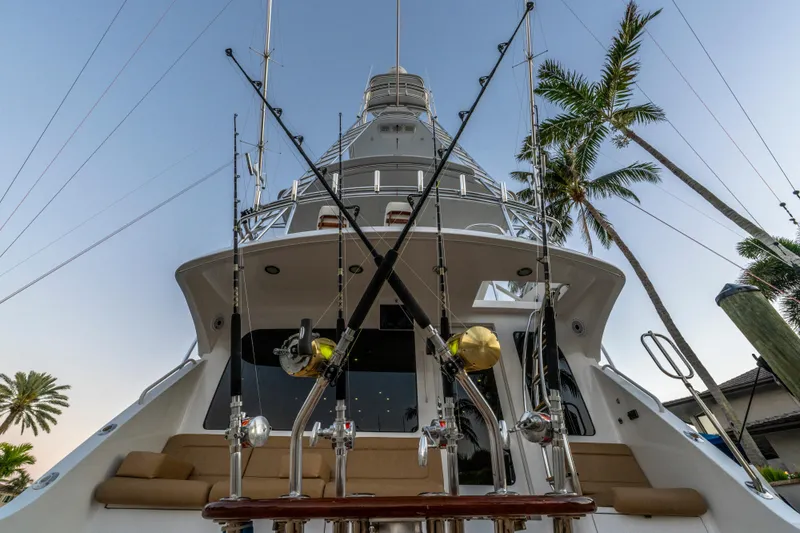 Cast Away Yacht Photos Pics 2008 Hatteras 68 Convertible yacht with fishing rods, palm trees in background.