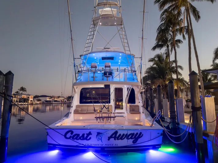 Cast Away Yacht Photos Pics 2008 Hatteras 68 Convertible yacht docked at sunset with blue underwater lights.
