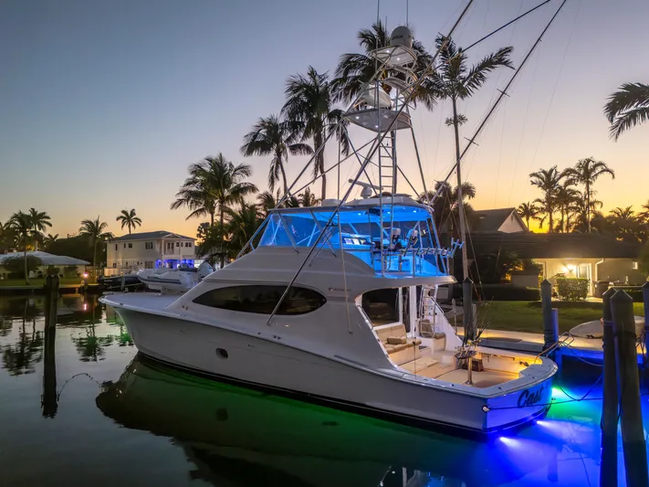 Cast Away Yacht Photos Pics 2008 Hatteras 68 Convertible yacht docked at sunset with vibrant blue lighting.