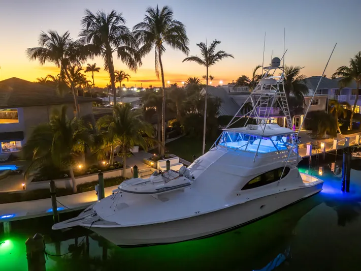 Cast Away Yacht Photos Pics 2008 Hatteras 68 Convertible yacht docked at sunset with palm trees and waterfront homes.