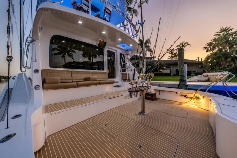 Cast Away Yacht Photos Pics 2008 Hatteras 68 Convertible yacht deck at sunset, featuring seating and fishing equipment.