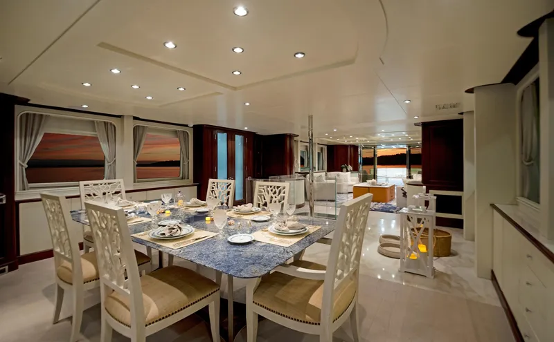Fortis Benetti 115 Classic Yacht Photos Pics Luxurious dining area on 2003 Benetti 115 Classic yacht, elegant table setting, sunset view.