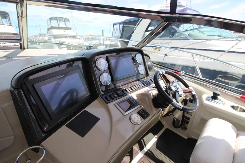 Yacht Photos Pics 2008 Sea Ray 44 Sundancer helm with dual screens and steering wheel in marina setting.
