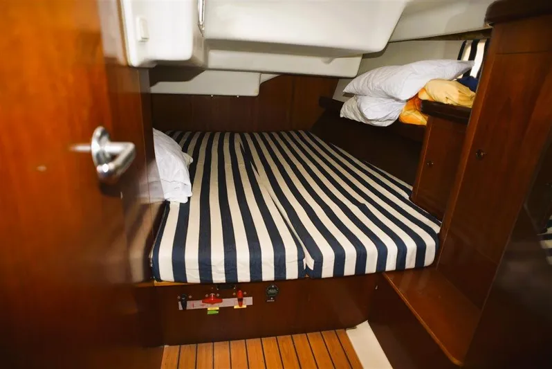  Yacht Photos Pics Cabin of Beneteau Oceanis 473 yacht, 2002 model, featuring striped bedding.