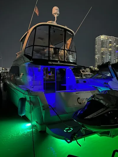 Chiquimu Yacht Photos Pics 2000 Sea Ray 480 Sedan Bridge yacht illuminated at night in marina.