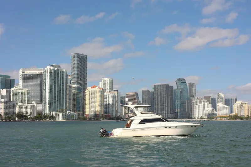 Chiquimu Yacht Photos Pics Sea Ray 480 Sedan Bridge yacht cruising near city skyline, 2000 model.
